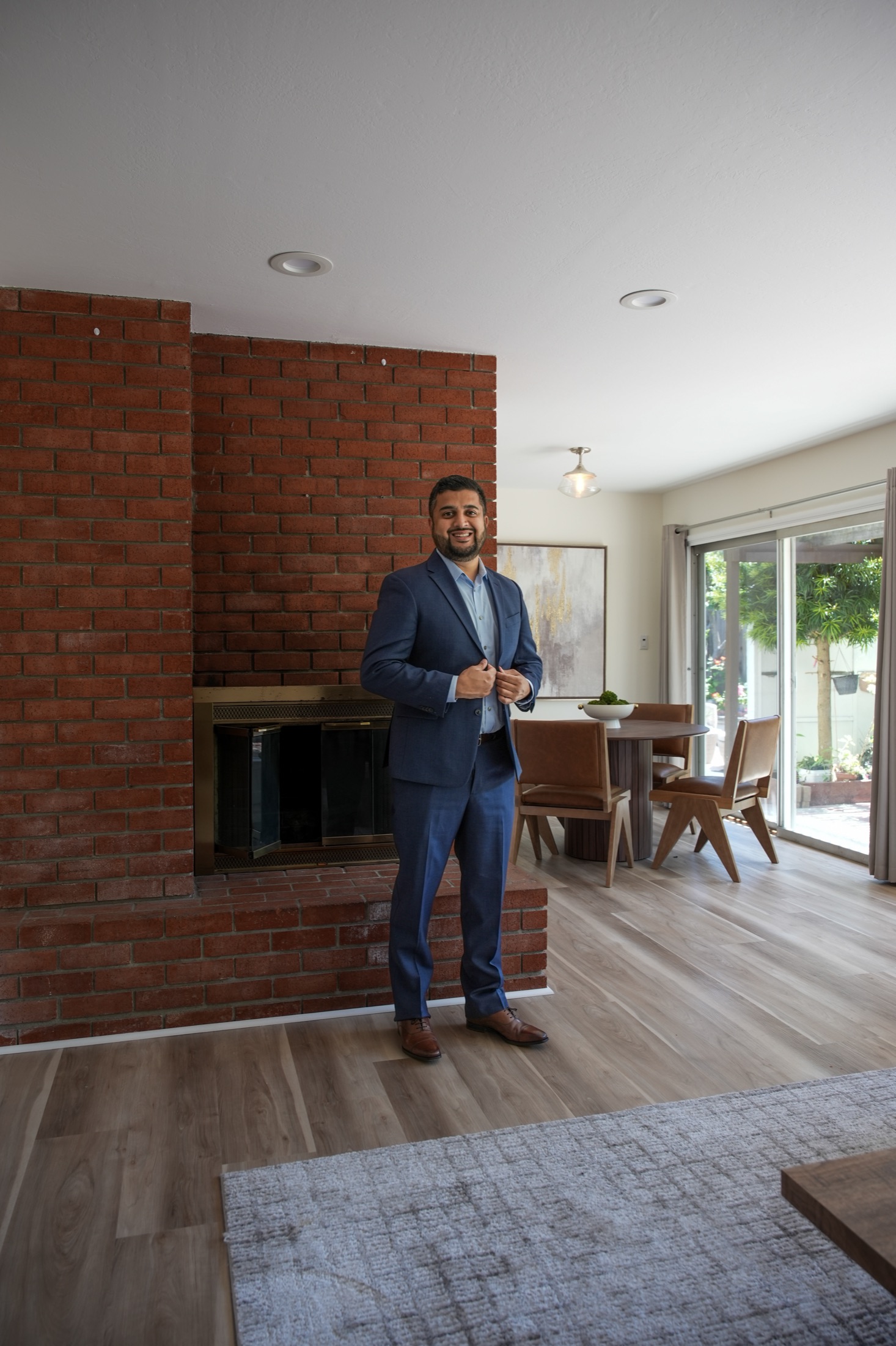 Muzamil Khan inside a staged East Bay home by a brick fireplace